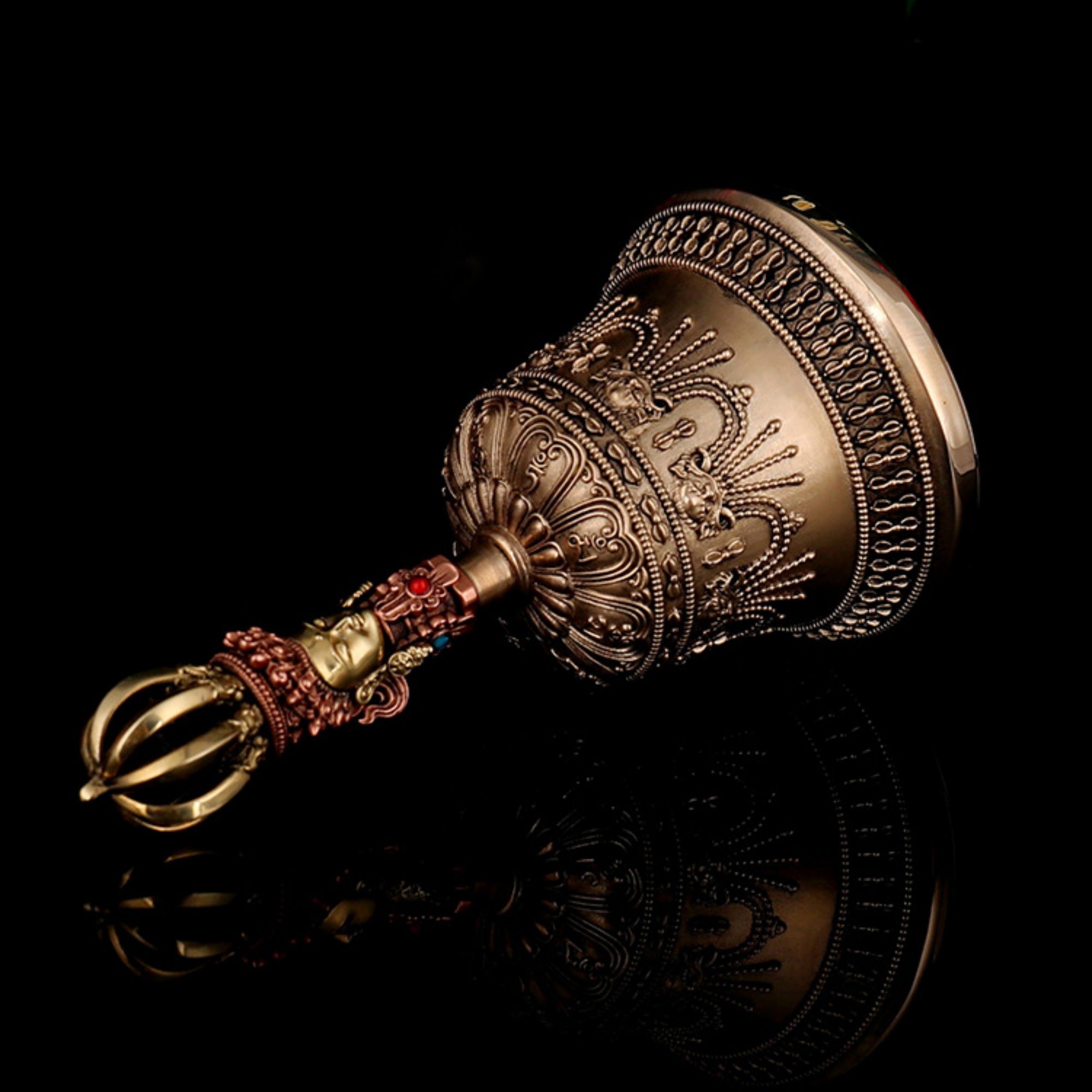Decorative brass bell with intricate designs on a black background