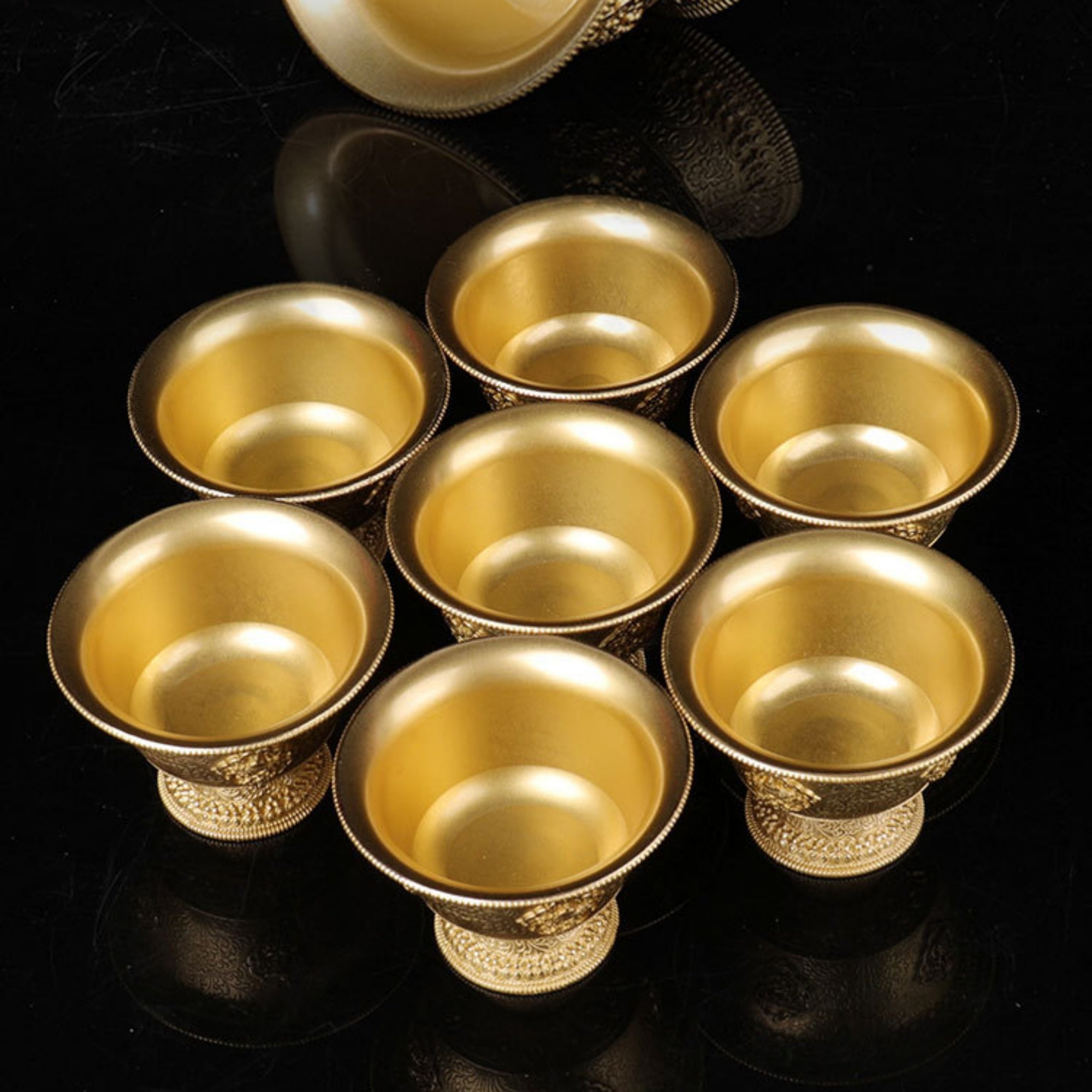 Set of gold cups on a dark surface