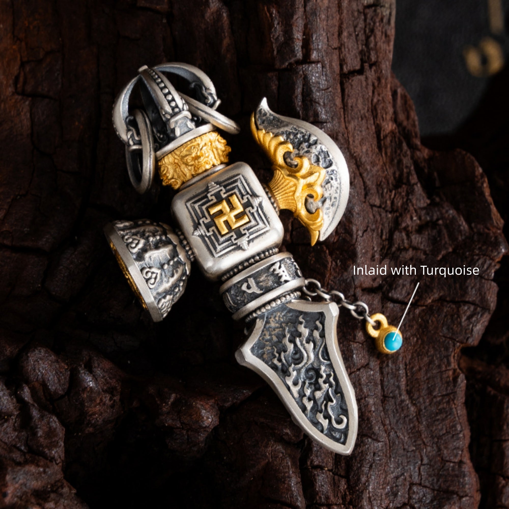 Decorative dagger pendant with intricate designs on a wooden surface