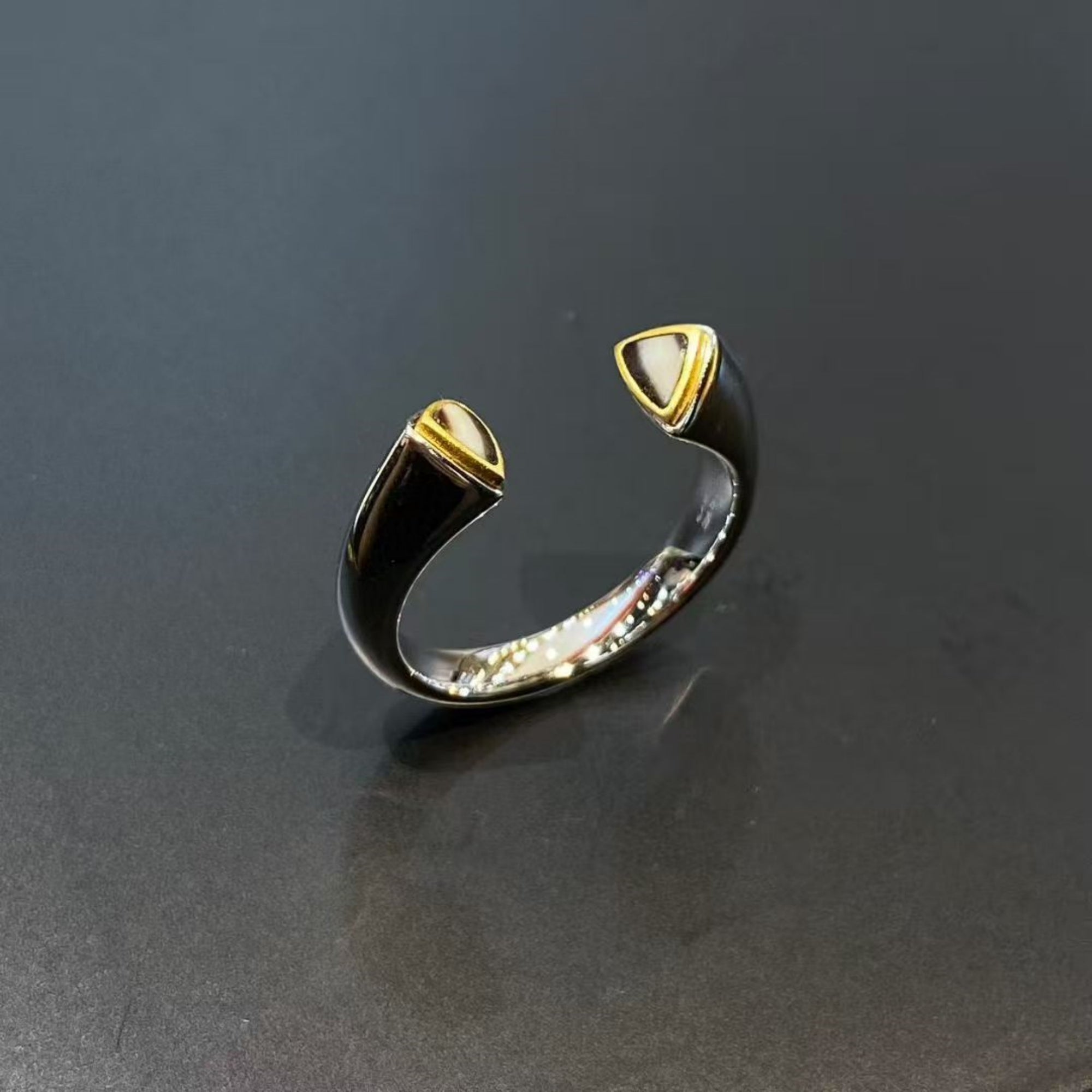 Gold and silver open ring on a dark gray background