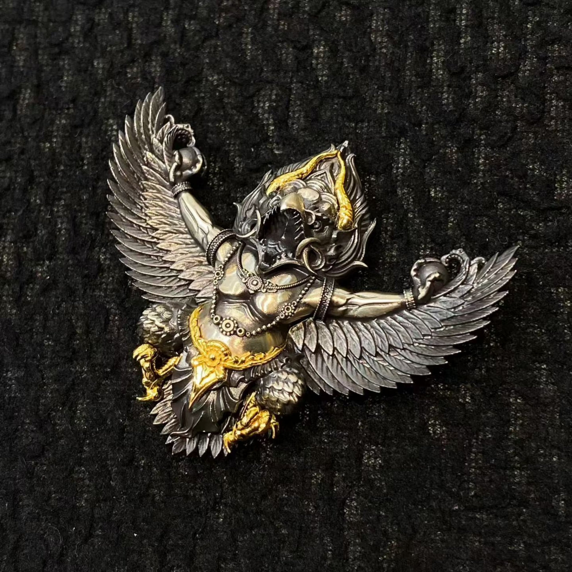 Decorative angel figurine with wings on a black textured background