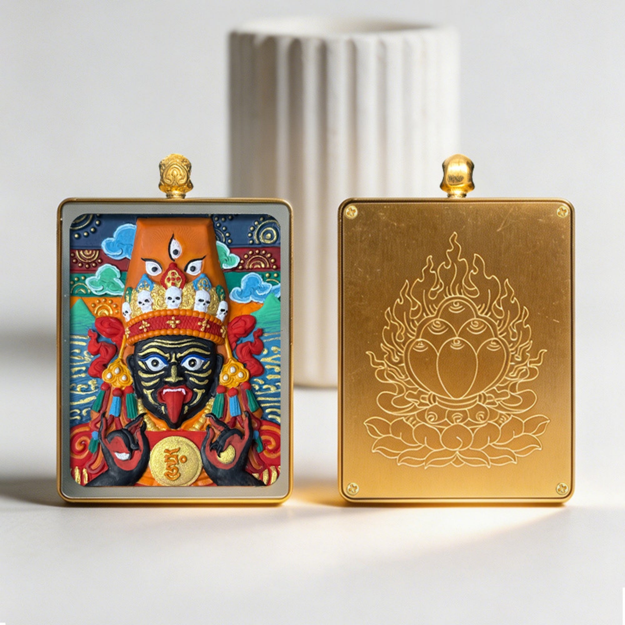 Two decorative boxes, one with a colorful deity illustration and the other with a gold embossed design, on a light background.