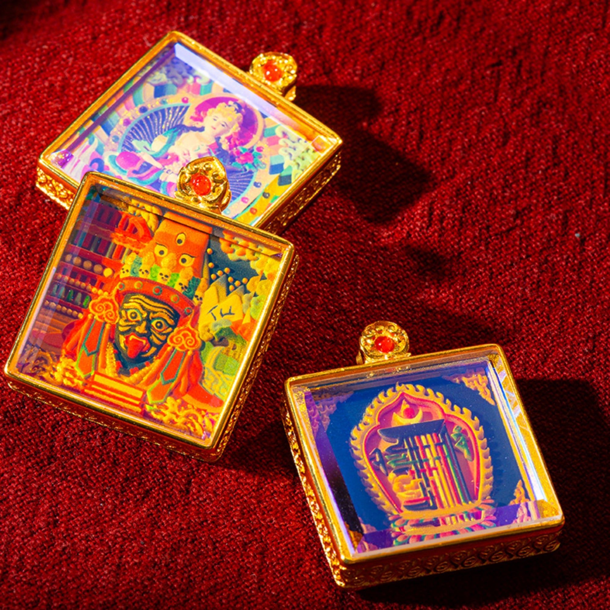 Three colorful decorative boxes with intricate designs on a red background