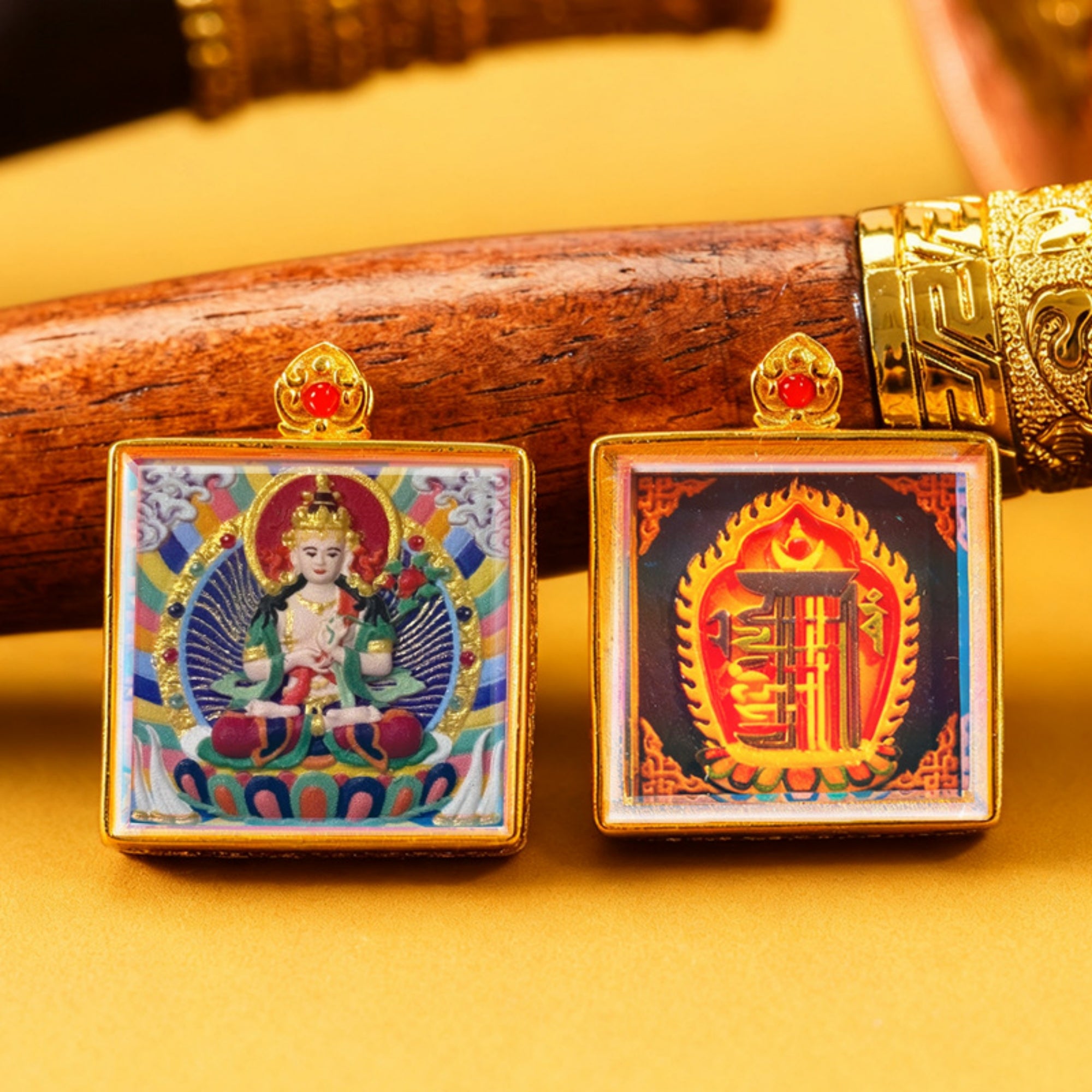 Two square pendants with religious iconography on a yellow background