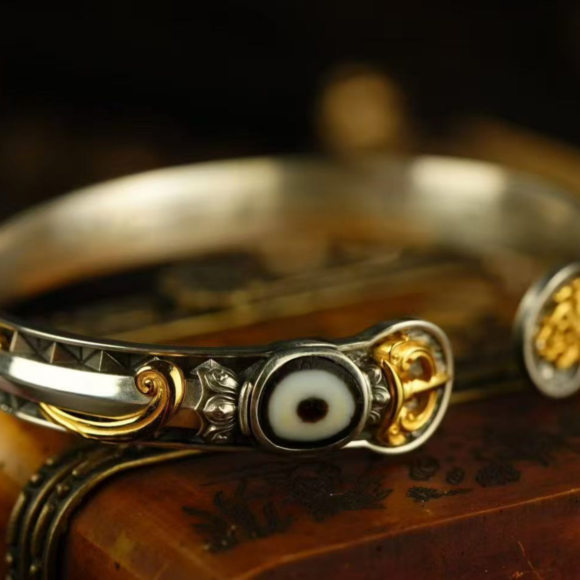 Decorative bracelet with eye design on a wooden surface