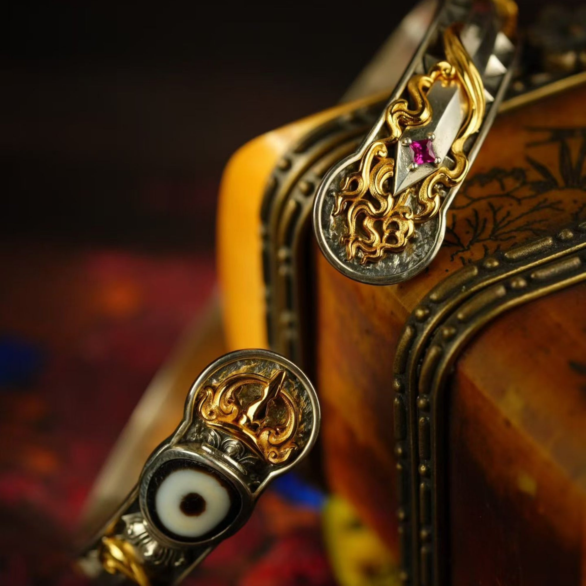 Close-up of ornate gold and silver jewelry with gemstones on a dark background