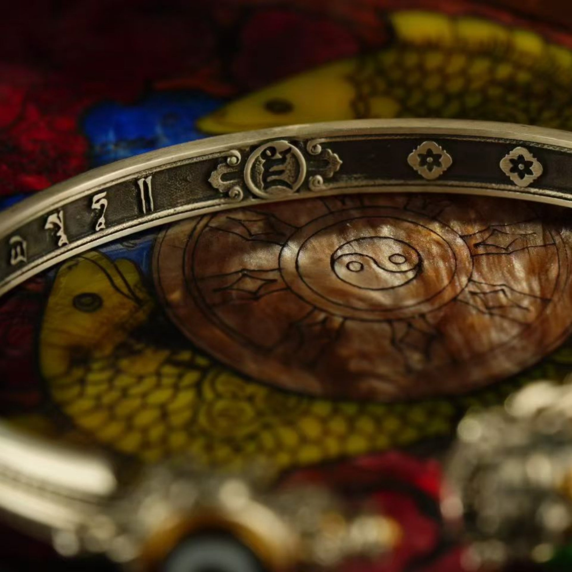 Decorative object with intricate designs and symbols on a colorful background