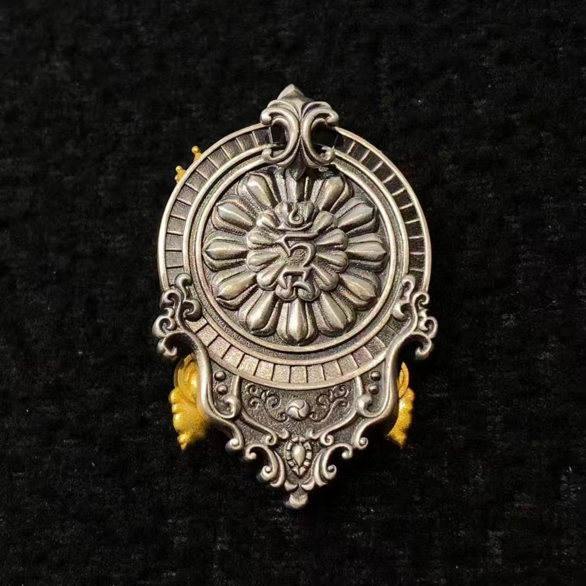 Decorative silver pendant with intricate designs on a black background
