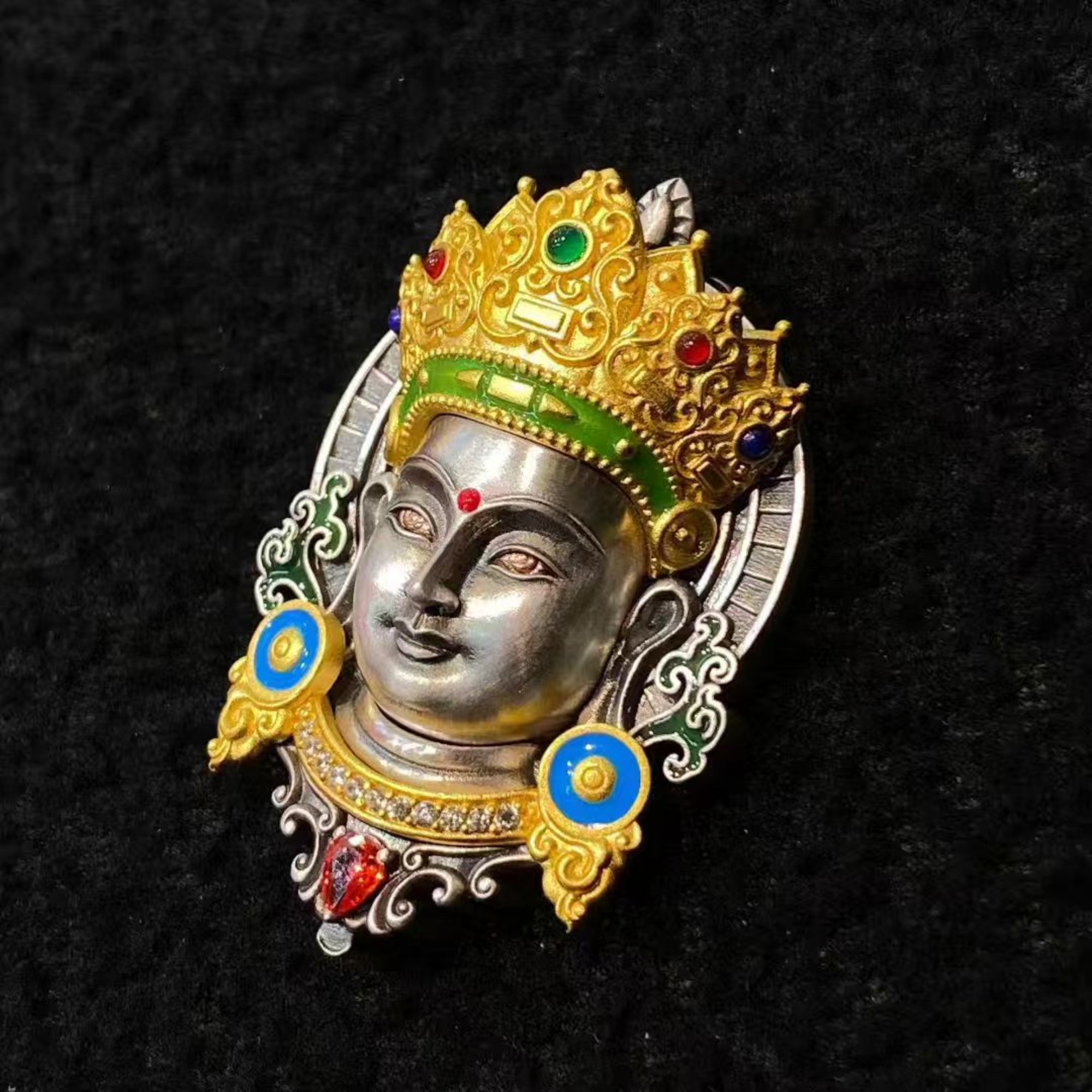 Decorative brooch with a face design and colorful accents on a black background