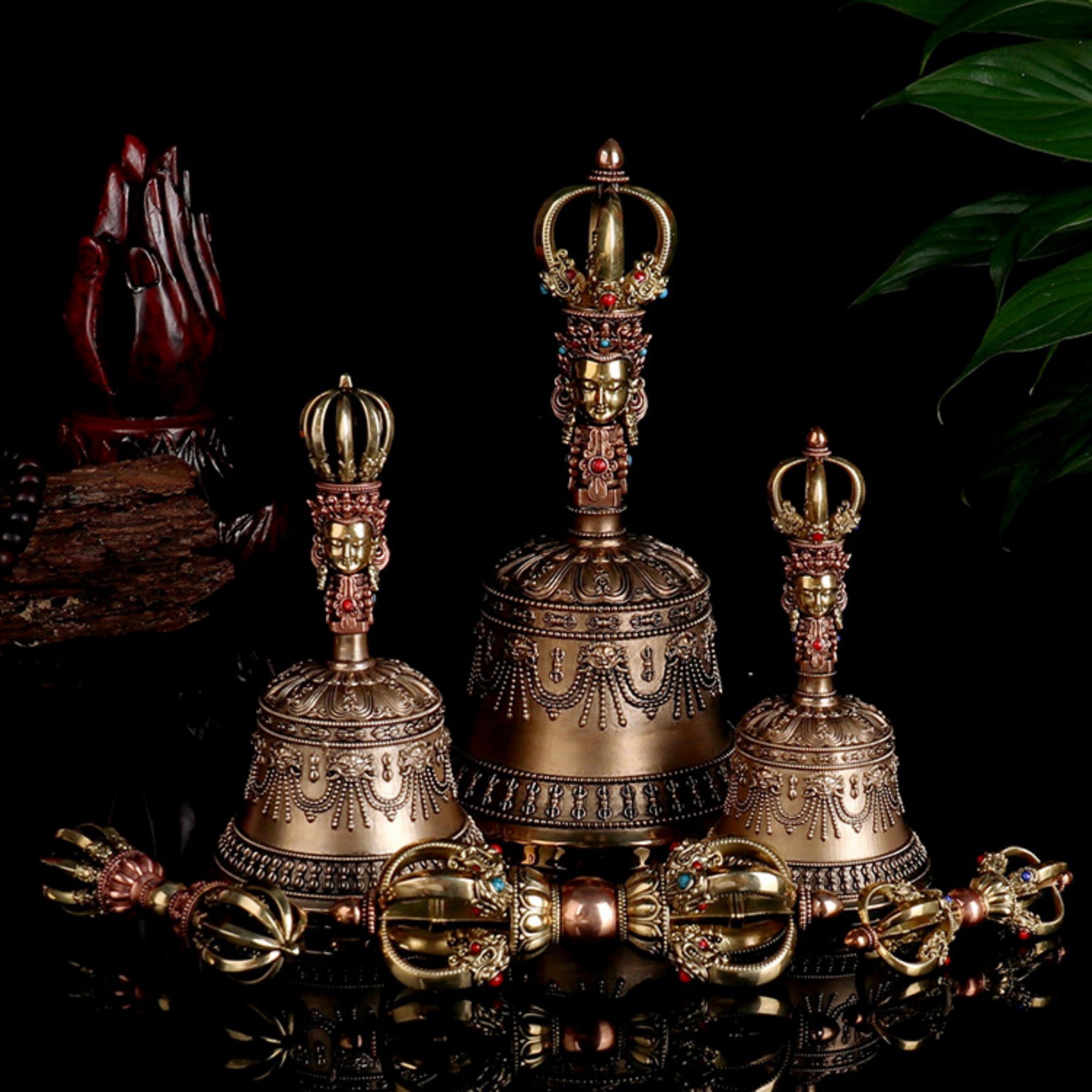 Decorative bronze bells with intricate designs on a dark background