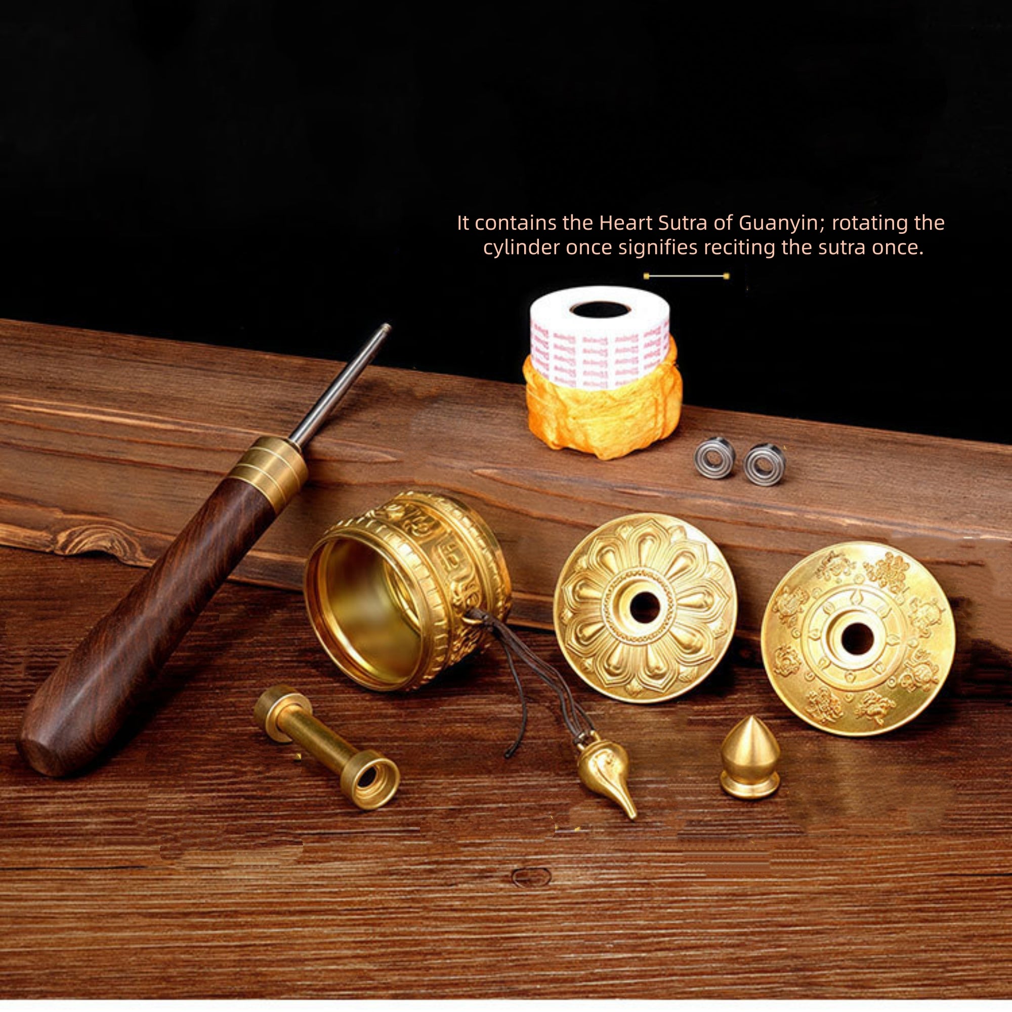 Gold Buddhist prayer wheel components on a wooden surface with text.