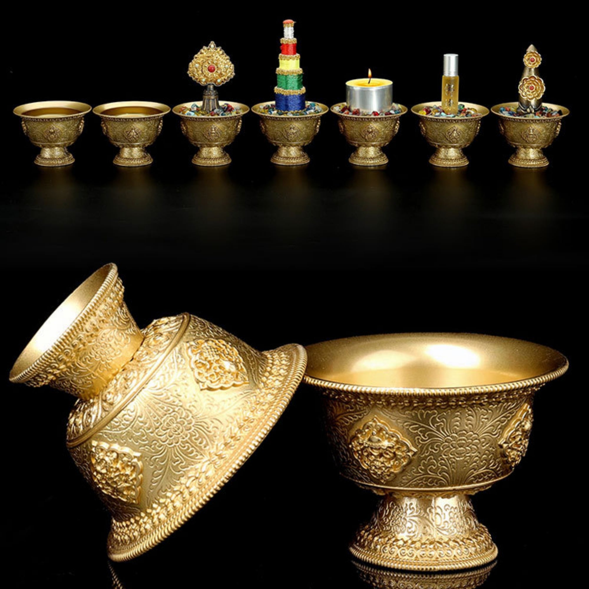 Set of gold decorative items including bowls and a lamp on a black background