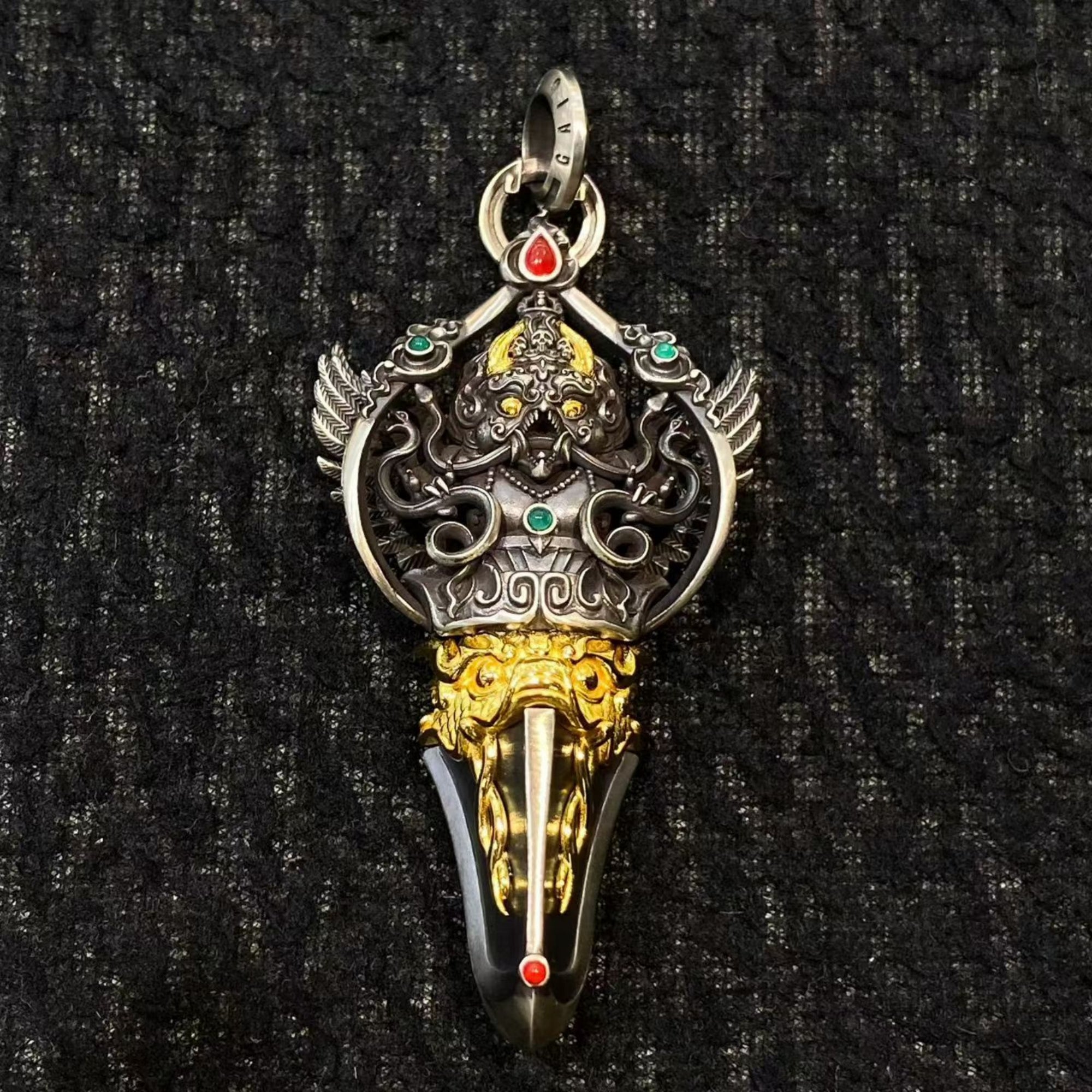 Decorative pendant with intricate designs on a black textured background