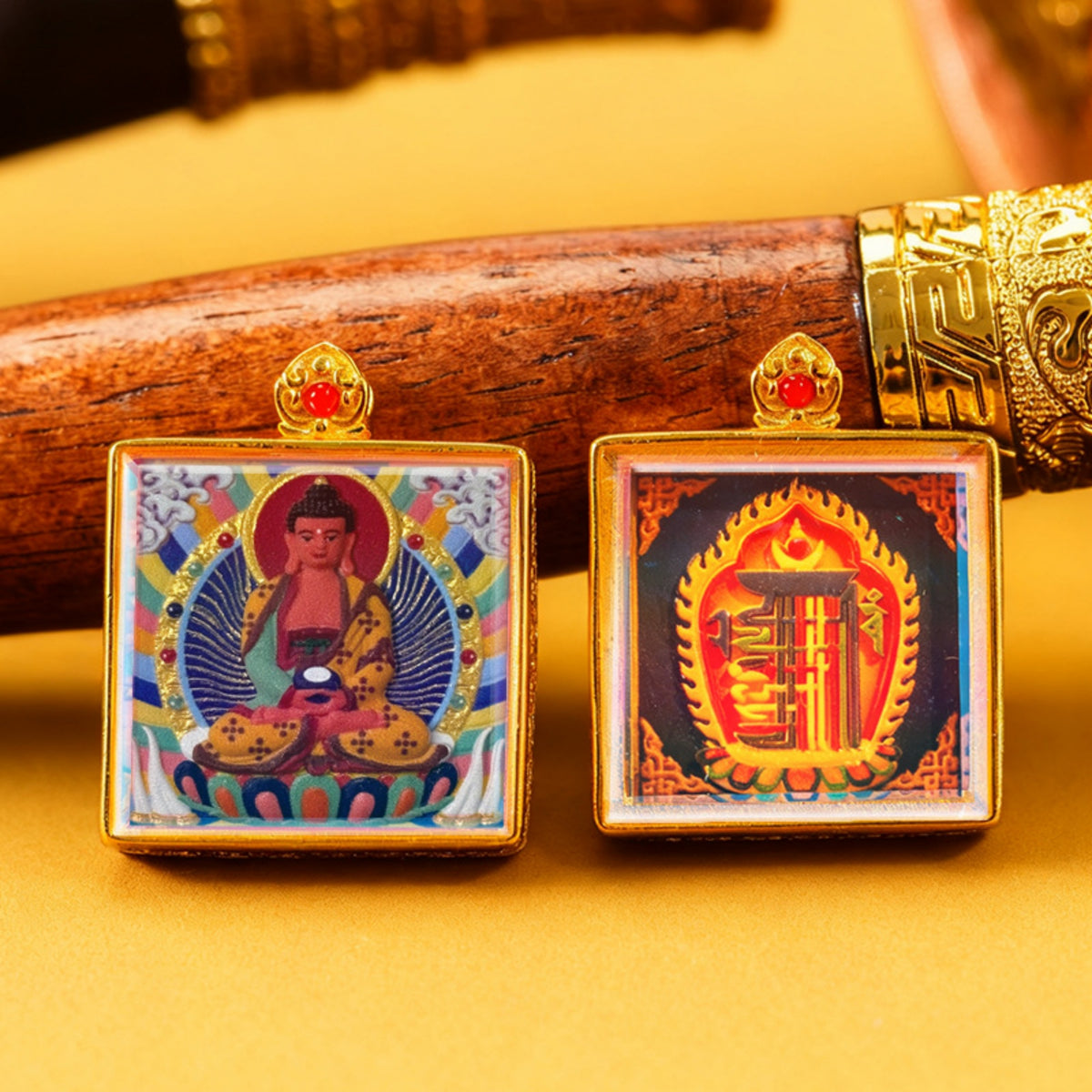 Two square pendants with religious iconography on a yellow background