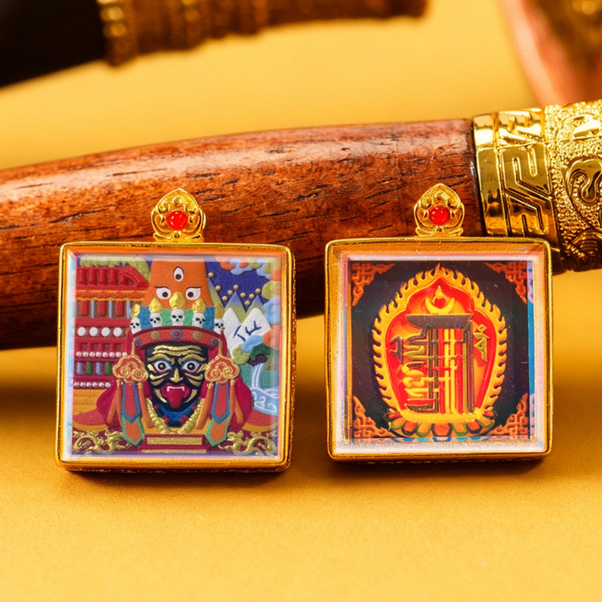 Two colorful square pendants with intricate designs on a yellow background