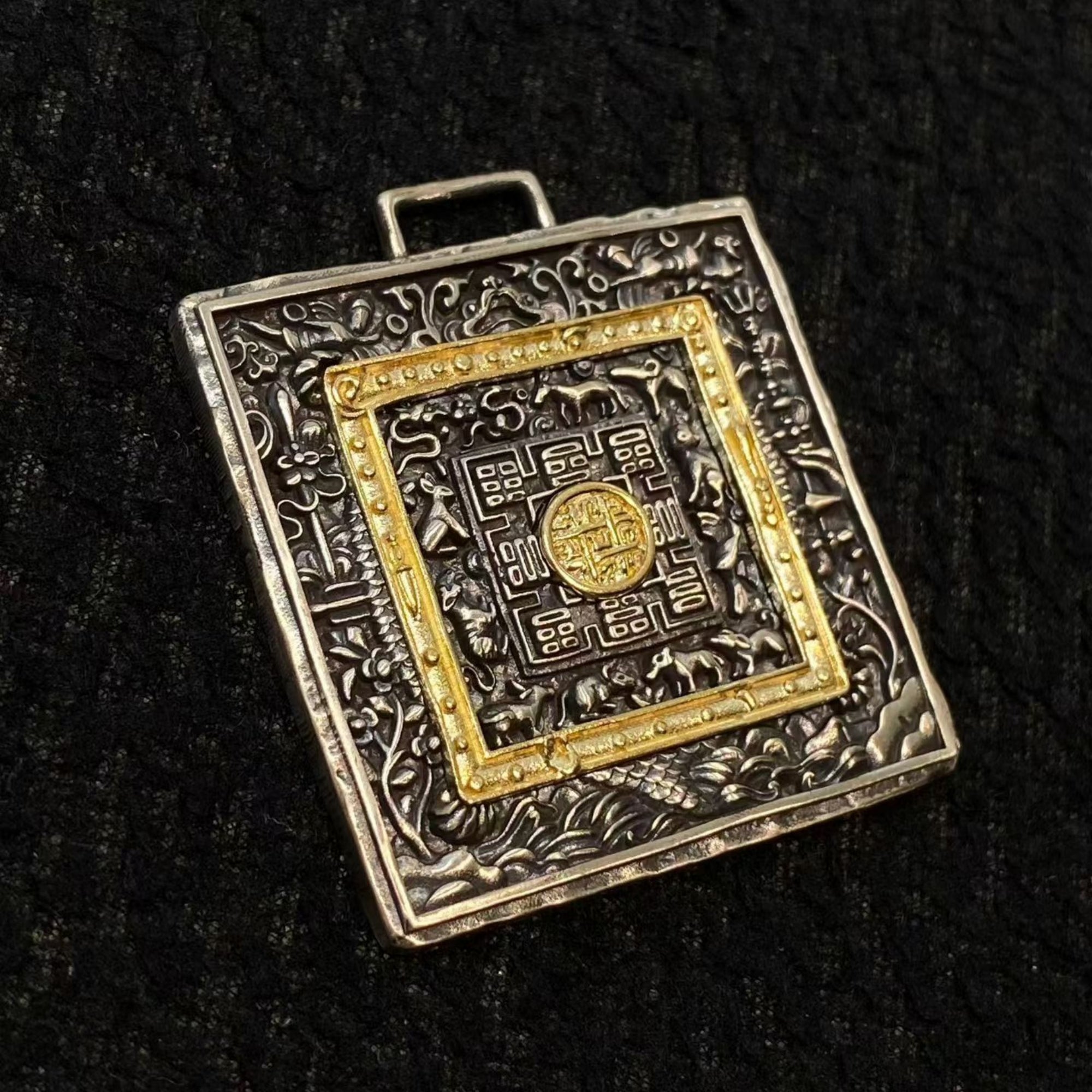 Decorative square pendant with intricate patterns on a black background