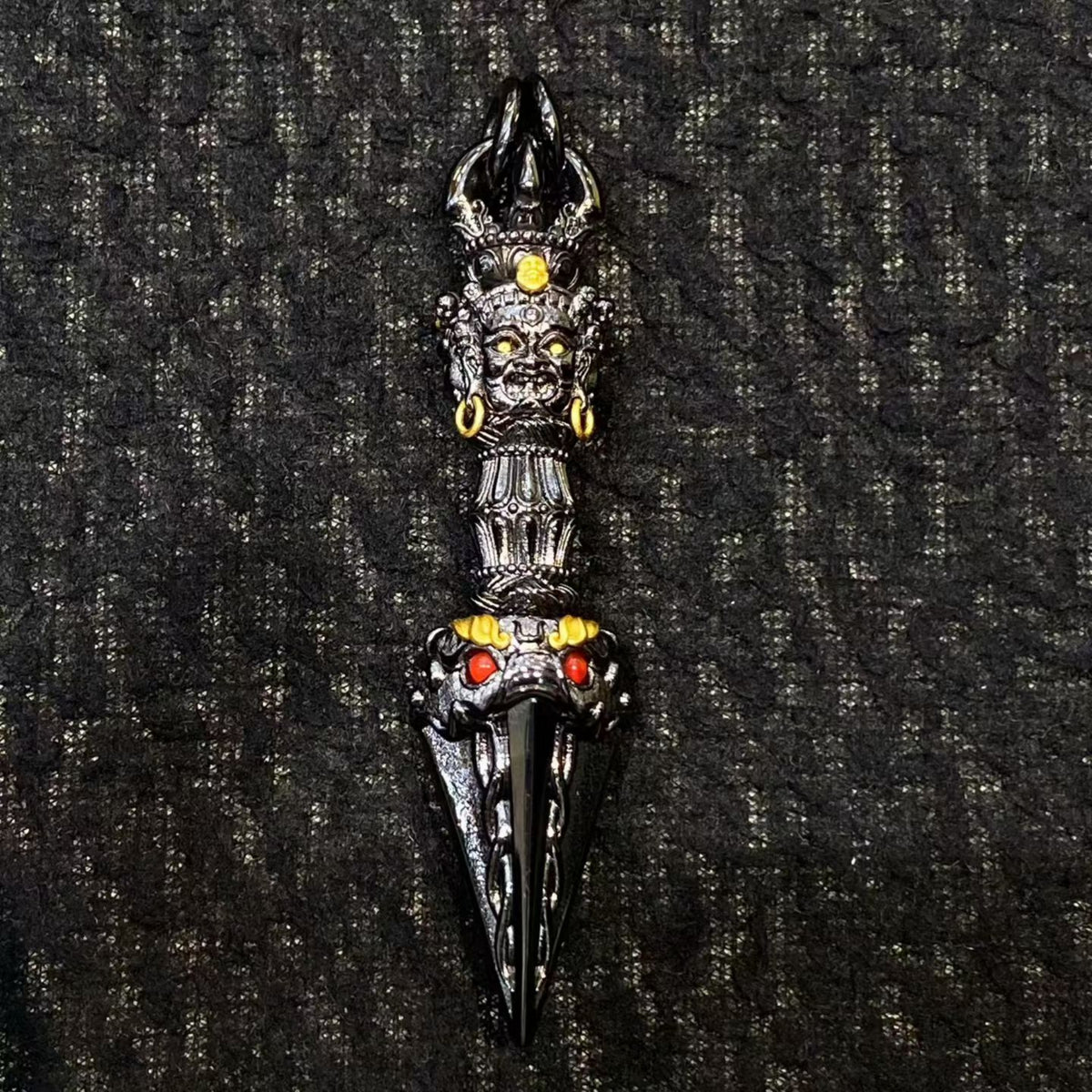 Decorative dagger with intricate designs on a textured black background