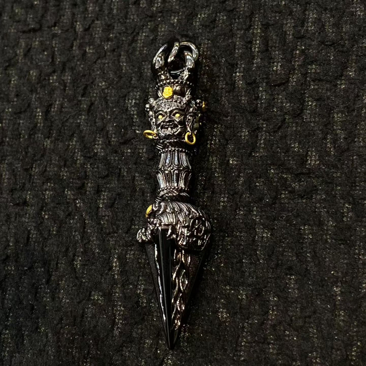 Decorative dagger with intricate designs on a dark textured background