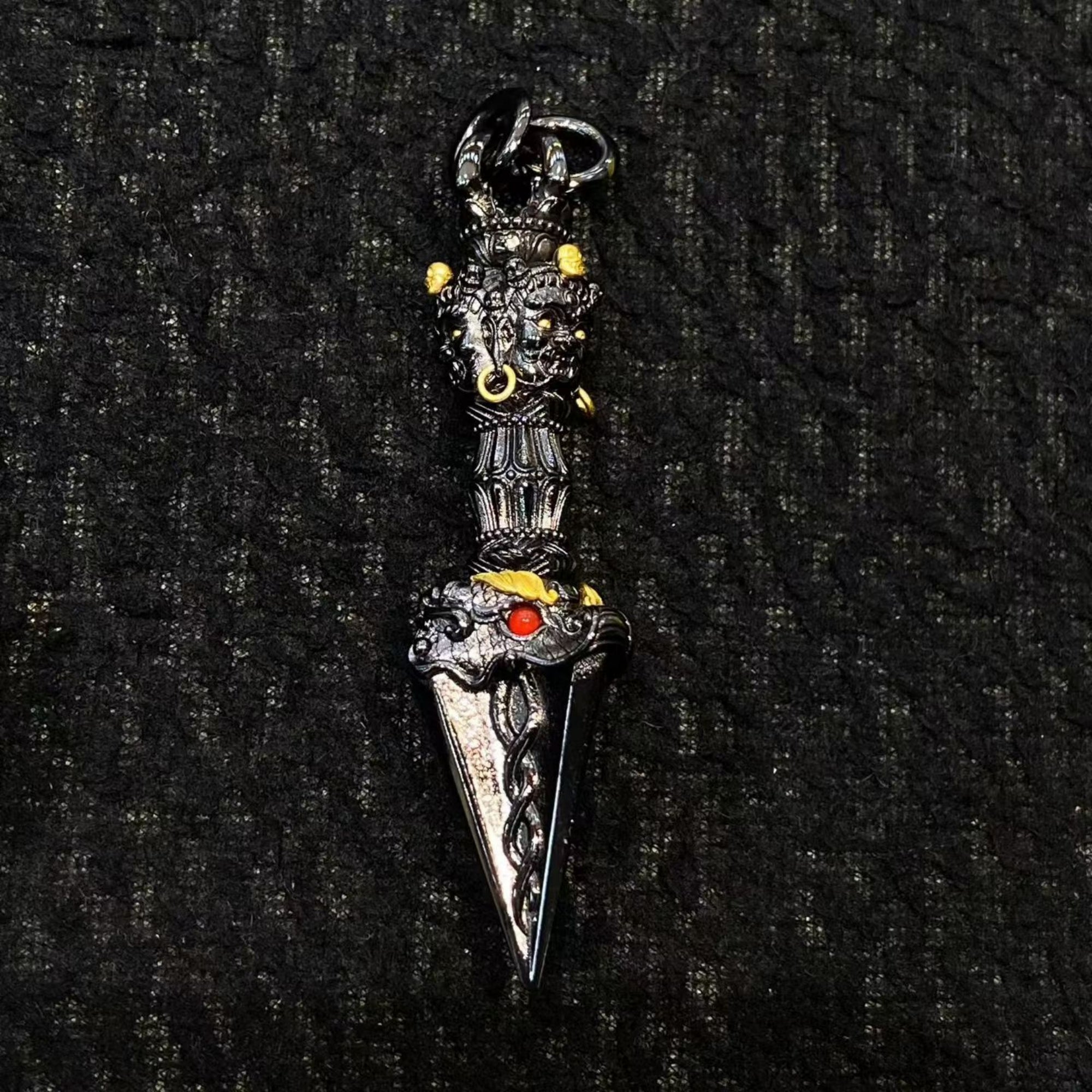 Decorative dagger with intricate designs on a black textured background