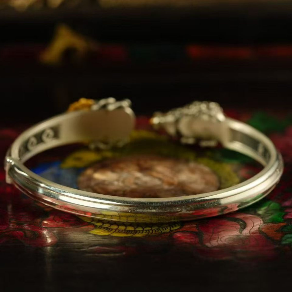 Silver bracelet on a colorful fabric background