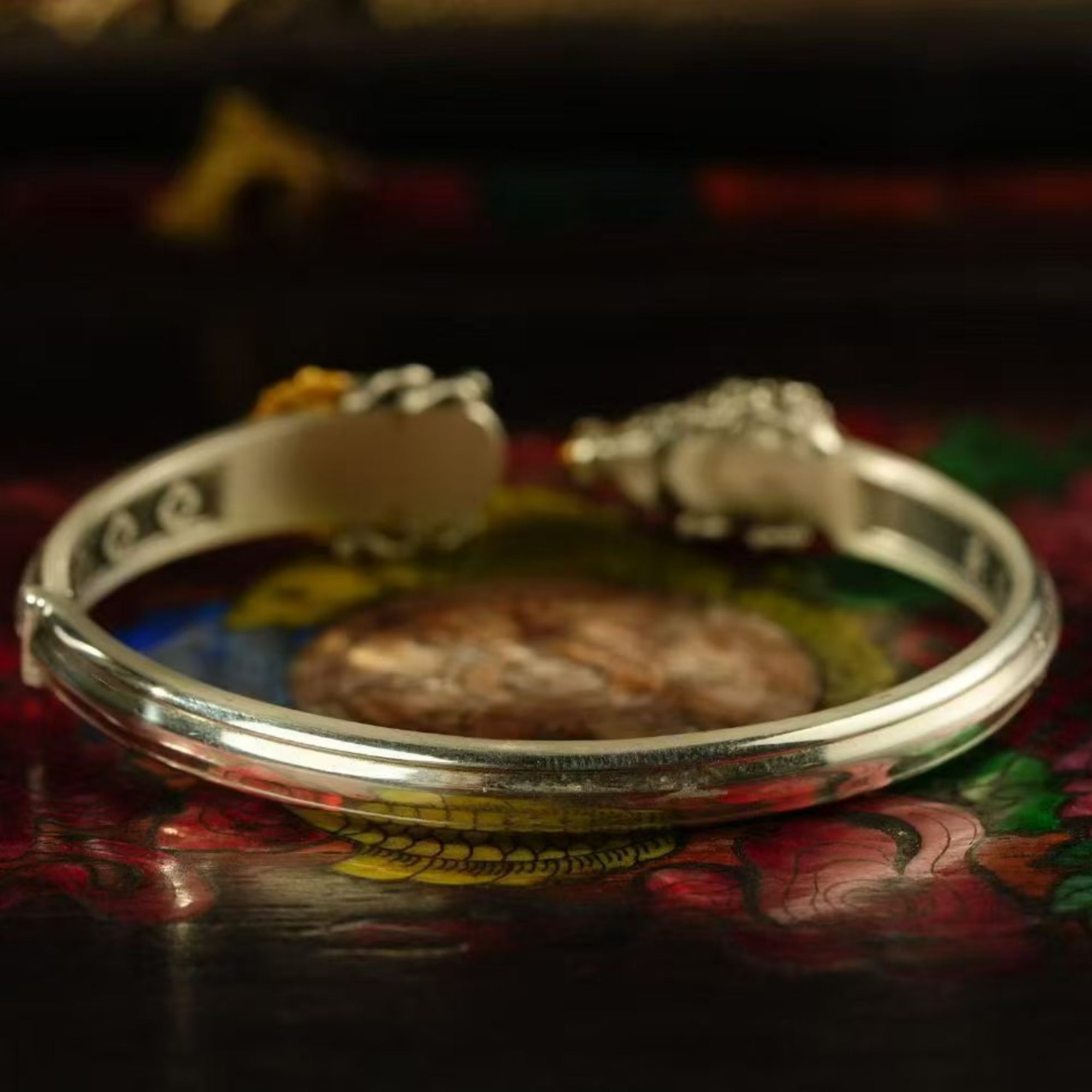 Silver bracelet on a colorful fabric background